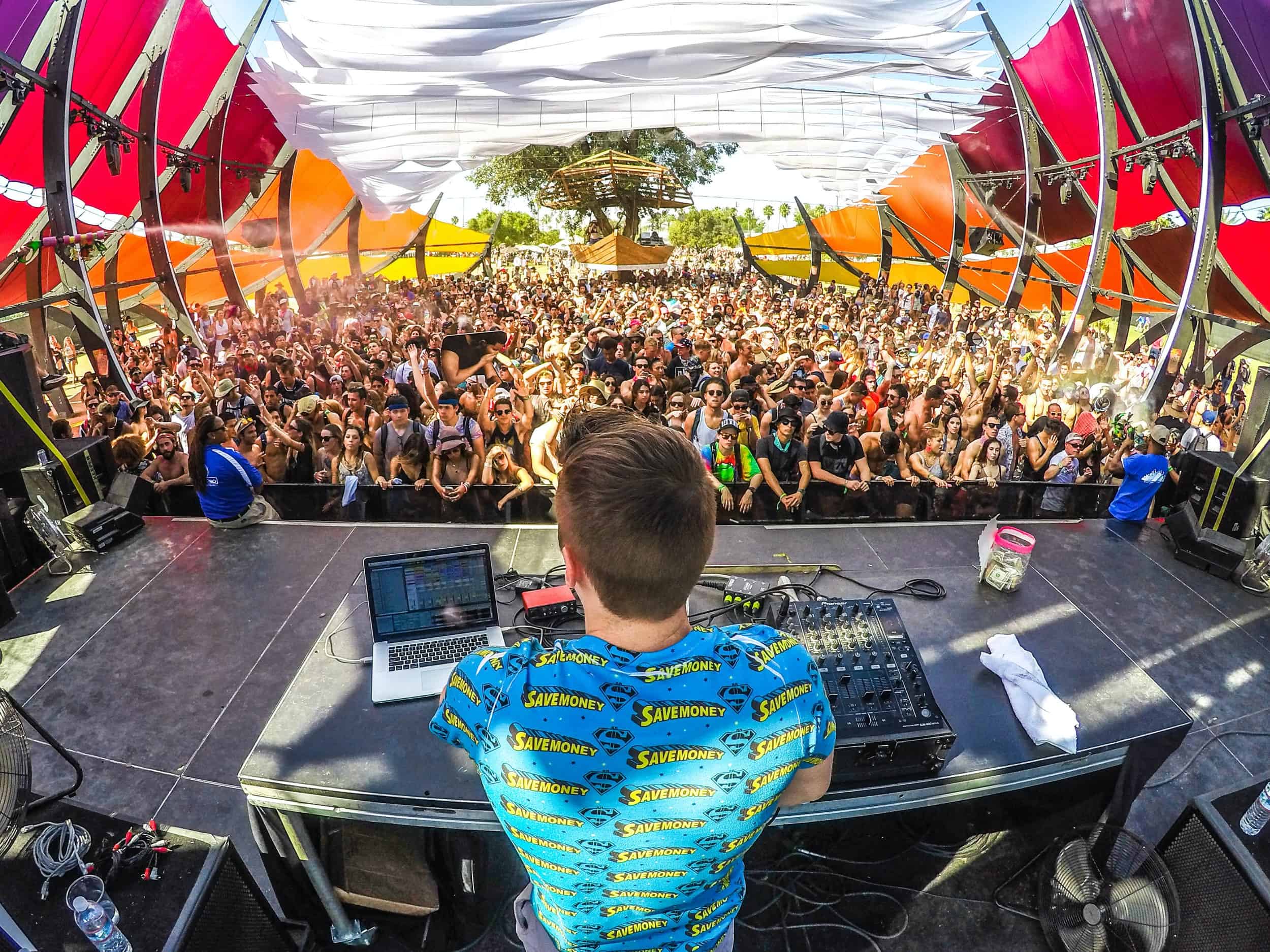 Un DJ anima a la multitud en una fiesta a la que asisten cientos de personas.