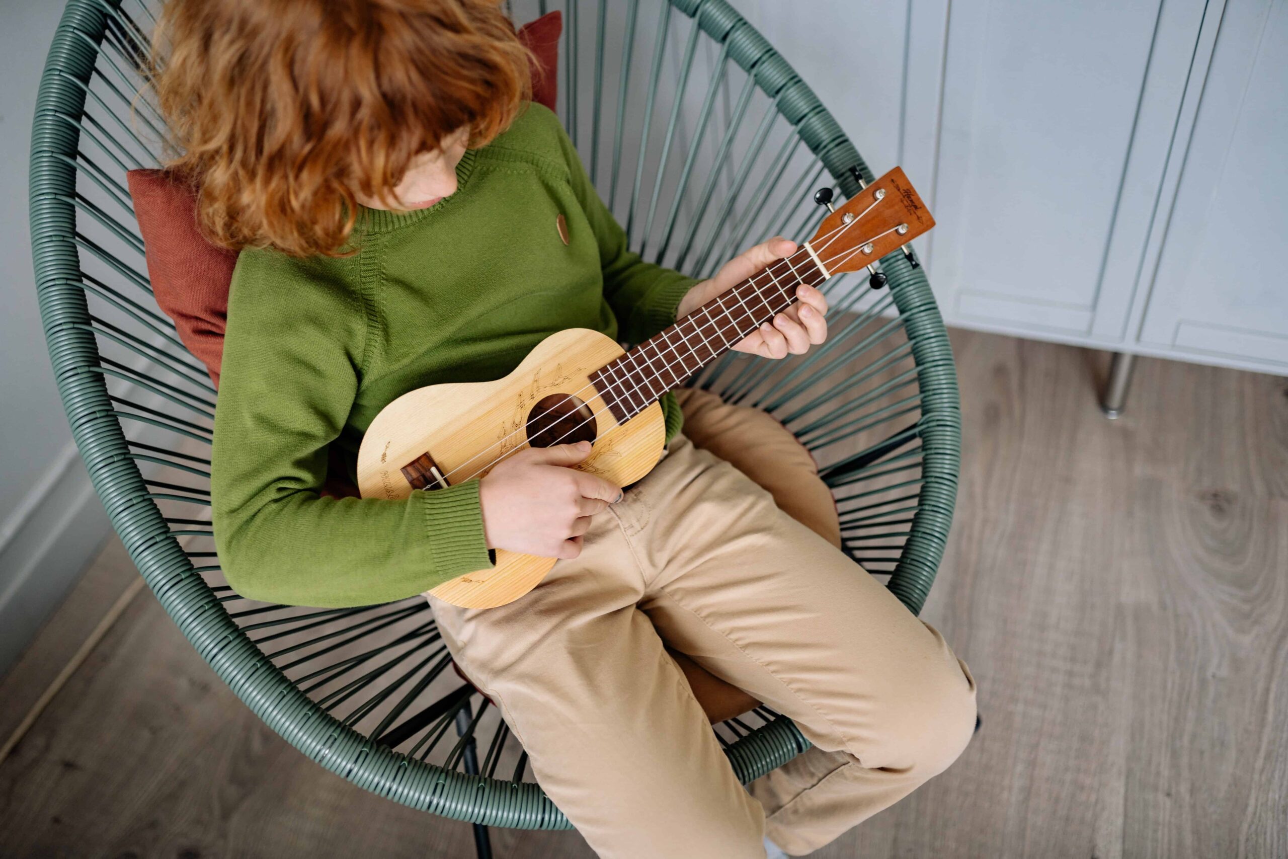 Un niño aprendiendo a tocar un ukelele.