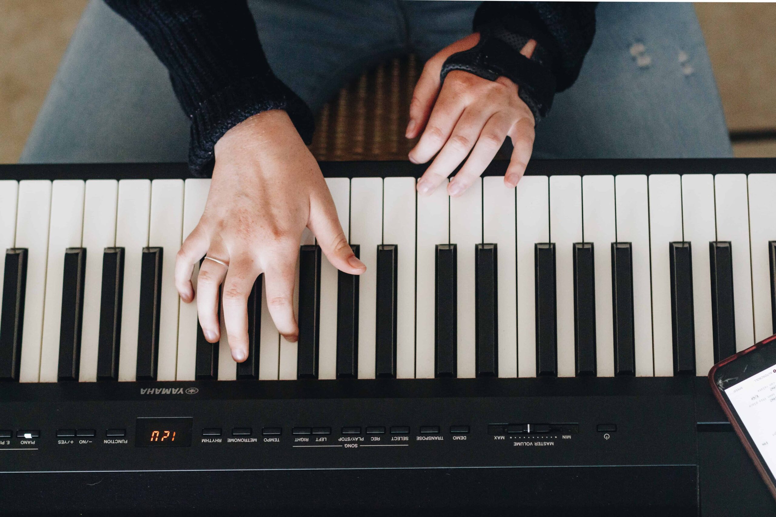 Un primer plano de las manos de una mujer mientras aprende a tocar el piano