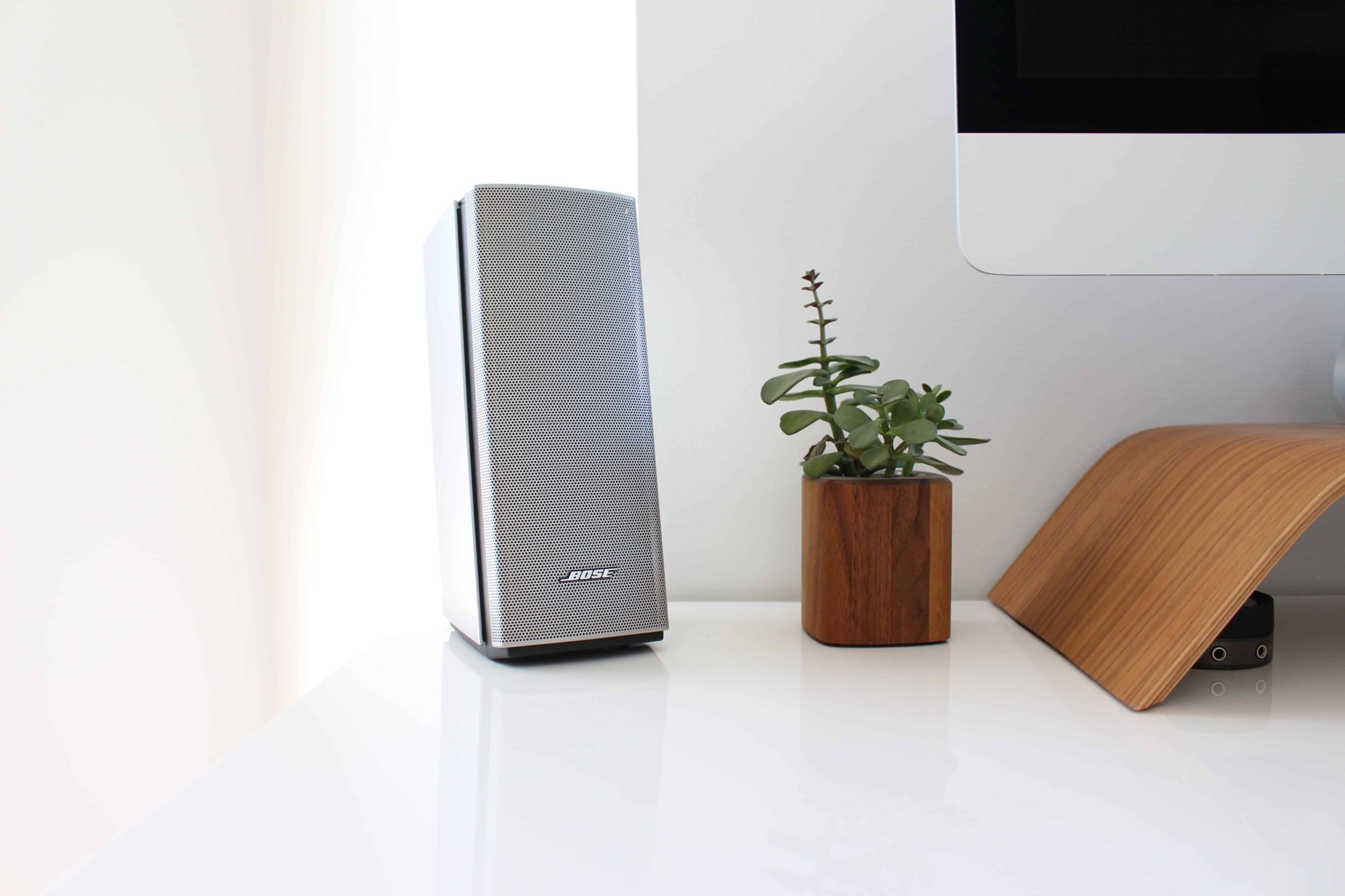 Un altavoz gris cerca de una computadora.