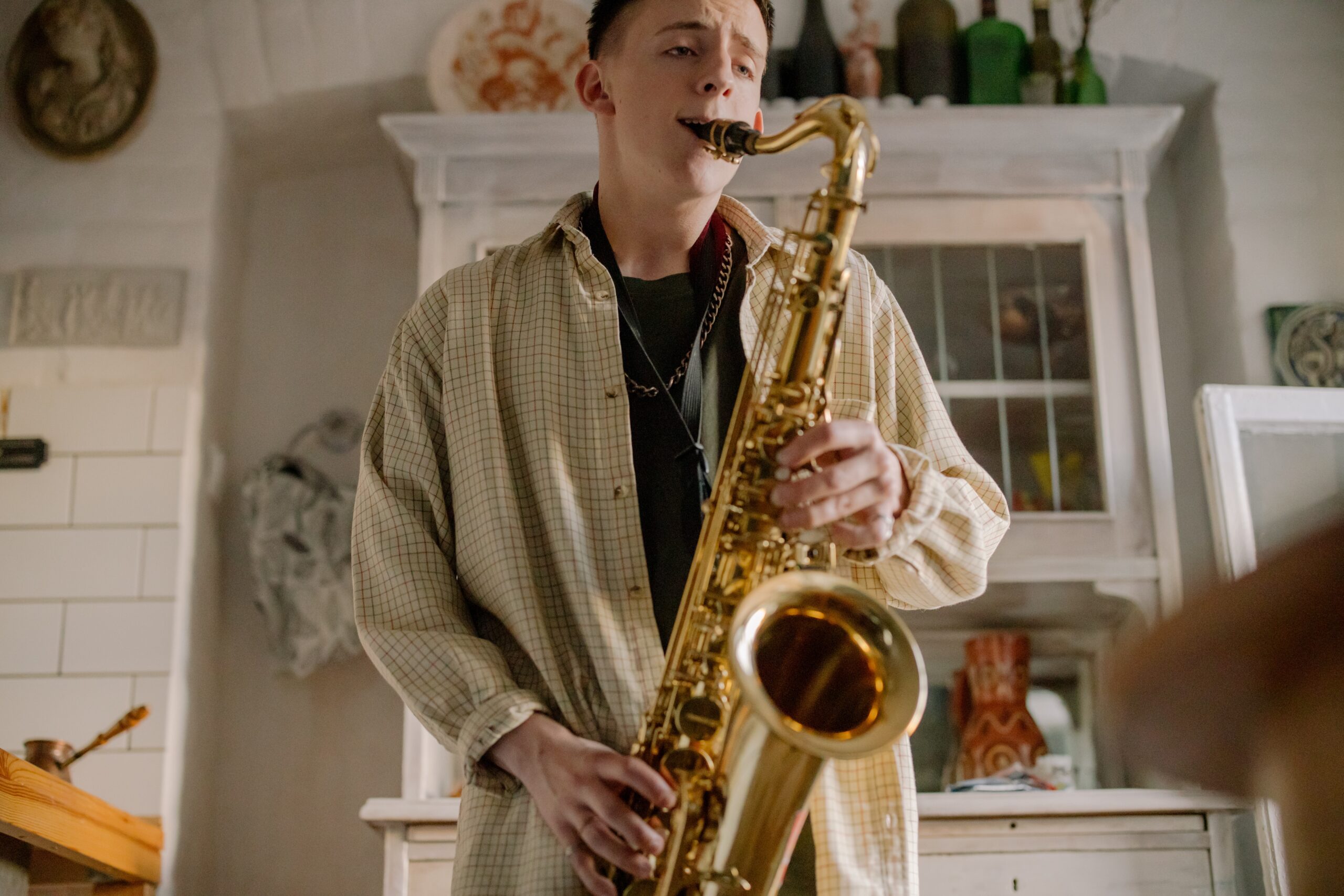 Un hombre tocando un costoso saxofón alto