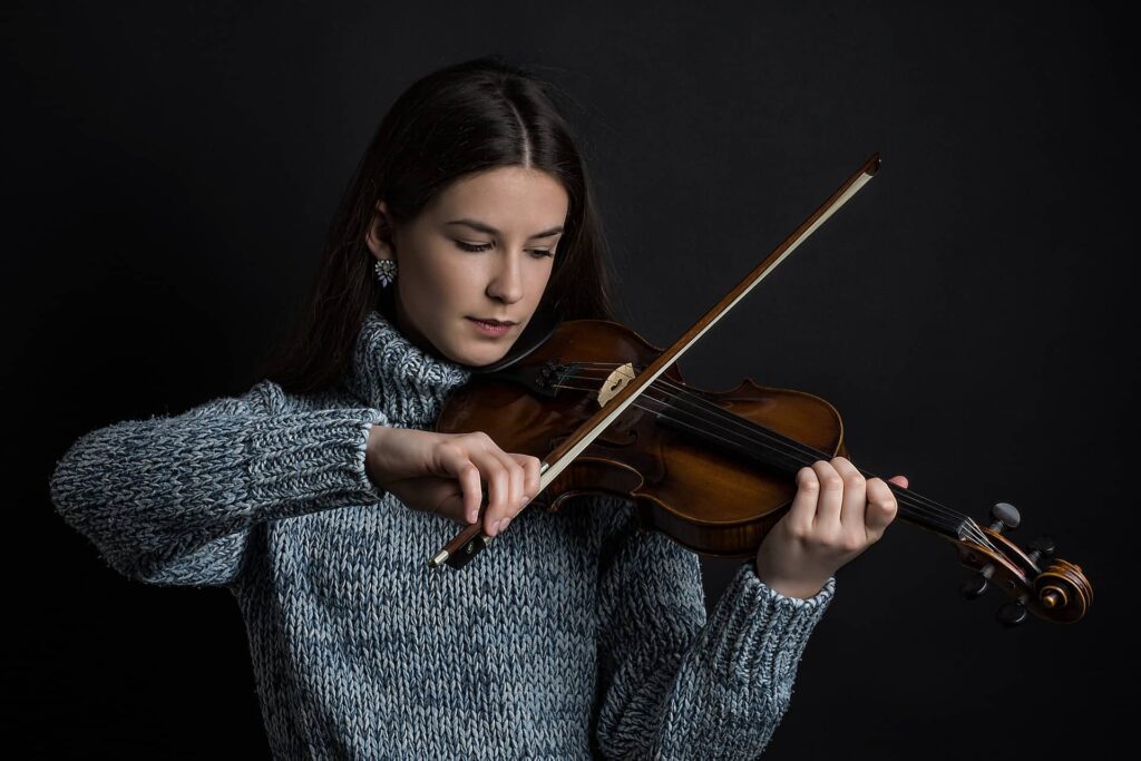 Un violinista que muestra cómo sostener un violín y el arco del violín.