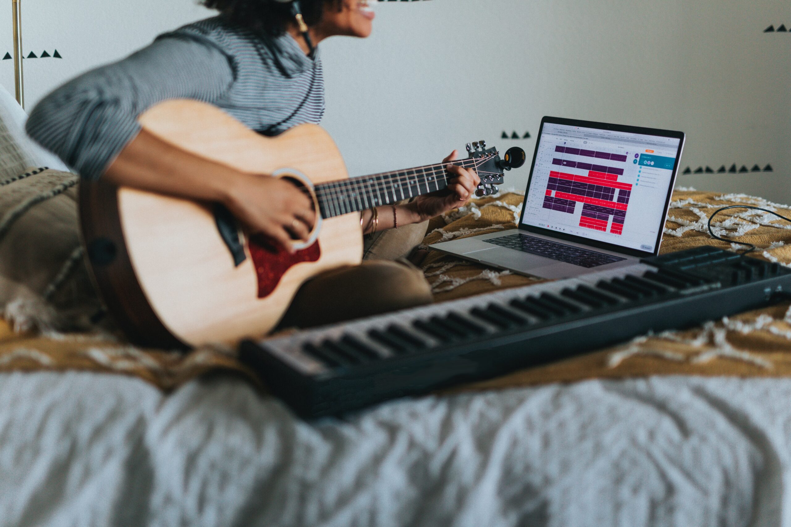 Una mujer aprendiendo una canción tocando la guitarra y el piano.