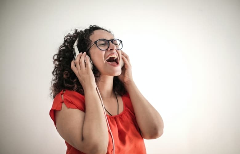 Una mujer cantando con los auriculares puestos