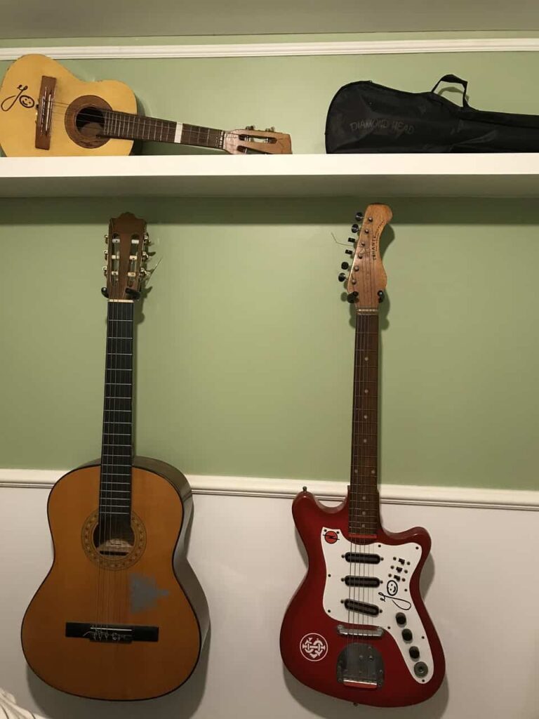 Dos guitarras colgadas de forma segura en la pared.
