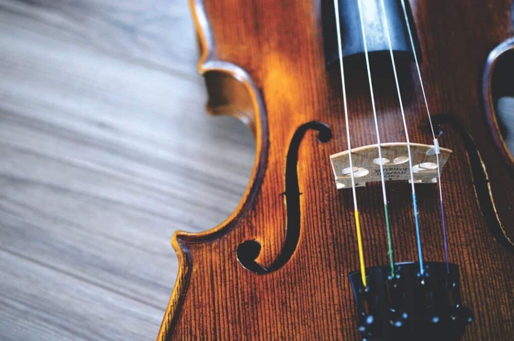 Violín tendido sobre una mesa de madera.